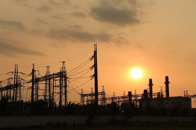 Photo centrale électrique contre le coucher du soleil orange clair avec concept d'énergie propre