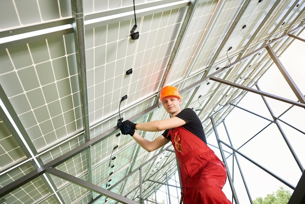 Centrale solaire à gros volumes Jeune homme à l'intérieur d'elle met en place un système