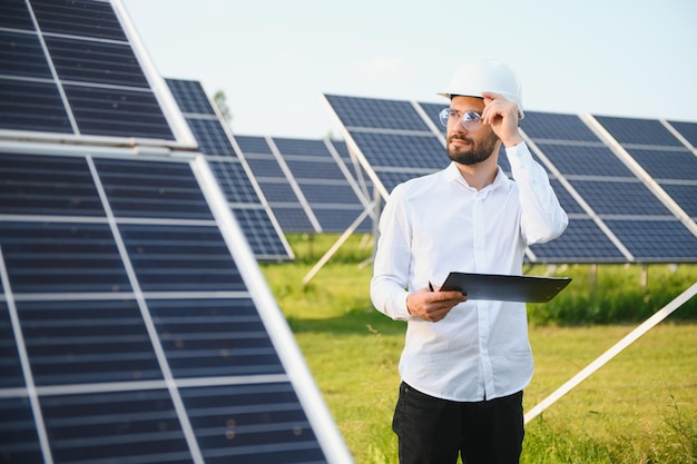 Centrale solaire de travailleur masculin sur fond de panneaux photovoltaïques