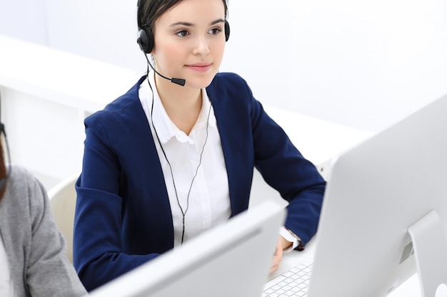 Centre d'appel Belle femme réceptionniste assis dans le casque au bureau du service client