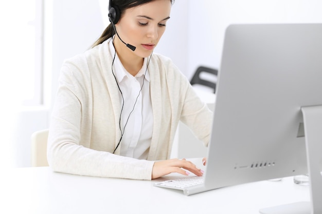 Centre d'appel Belle femme réceptionniste assis dans le casque au bureau du service client