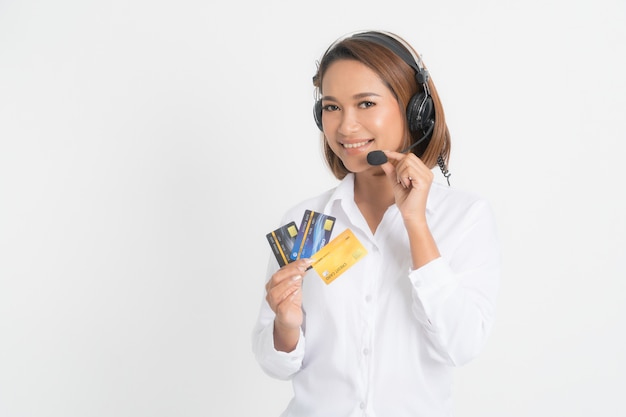 Centre d'appels femme avec casque et carte de crédit.