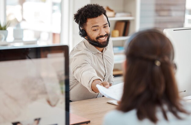 Photo centre d'appels papier et sourire à une femme d'un collègue au bureau au bureau contactez-nous crm et le travailleur du support client remettent des documents à un collègue pour un objectif de travail d'équipe ou un apprentissage dans un travail de conseil