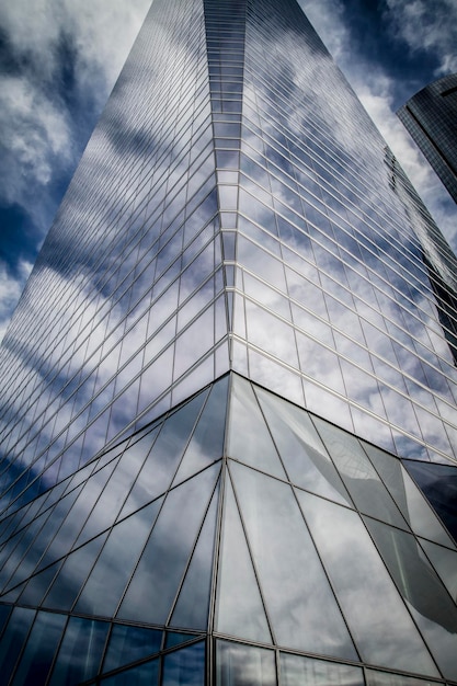 centre, gratte-ciel avec façade en verre et nuages reflétés dans les fenêtres