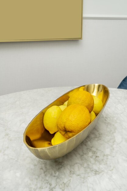 Un centre de table allongé en laiton poli rempli d'oranges et de citrons