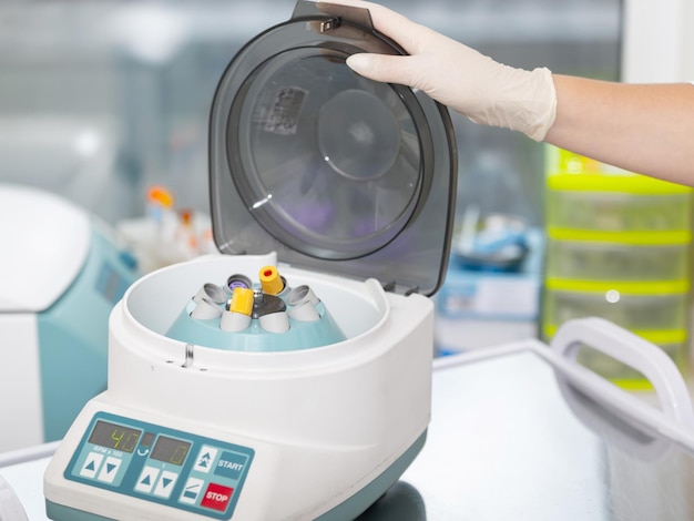 Centrifugeuse médicale. Scientifique chargeant un échantillon à la centrifugeuse dans le laboratoire médical ou scientifique