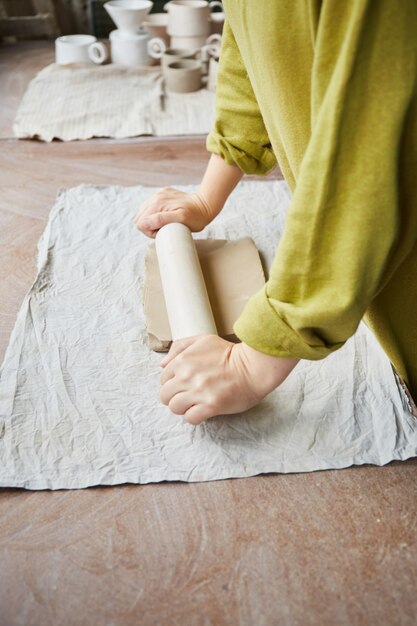 Céramiste travaillant dans un atelier de poterie. Les mains du céramiste sales d'argile. Processus de création de poterie. Maître céramiste travaille dans son atelier