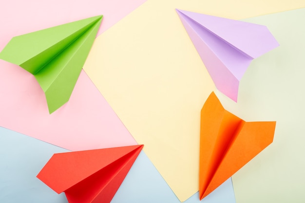 Cercle d'avions en papier de couleur origami sur le fond de couleur