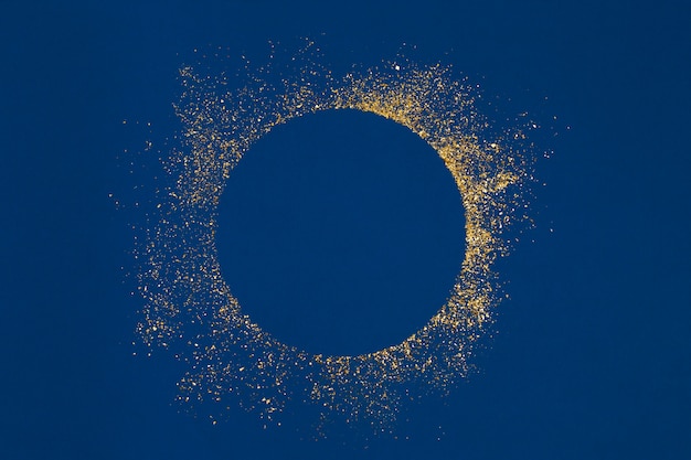 Cercle éclaboussures De Paillettes D'or Avec Centre Vide Sur Fond Bleu.