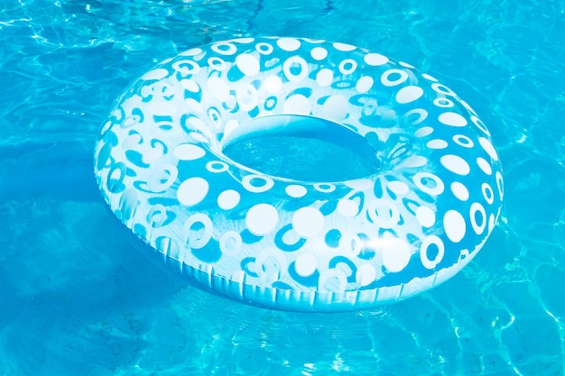 Cercle de natation gonflable dans la piscine bleue en plein air