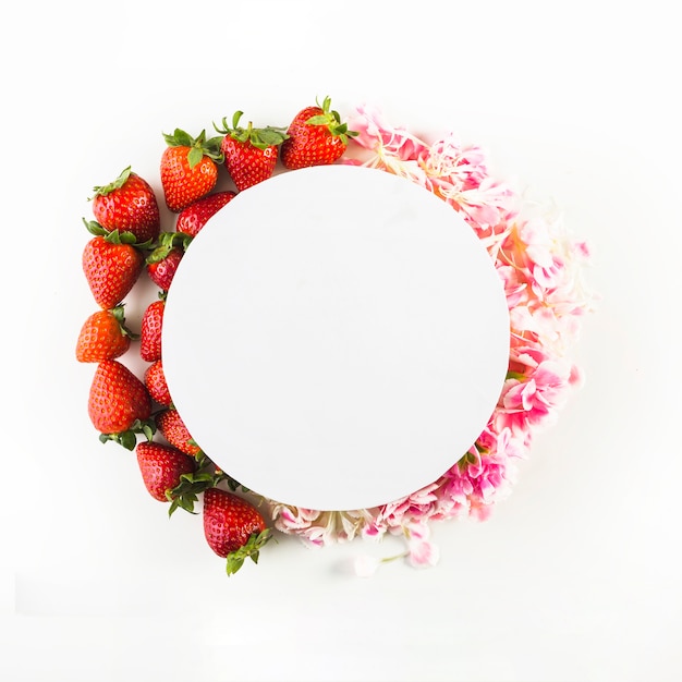 Photo cercle de papier sur les fraises et les pétales