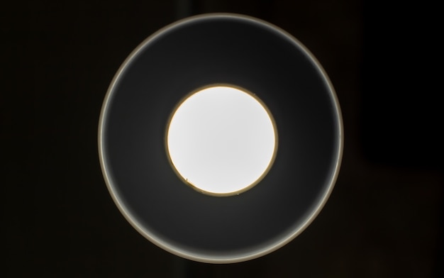 Cercles lumineux blancs sur fond noir. Il y a un endroit pour insérer du texte, une texture. Manière simple