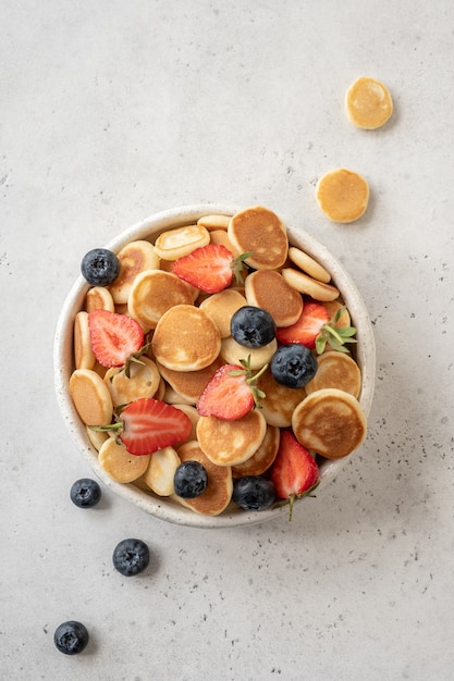 Céréales de crêpes dans un bol avec fraise et myrtille