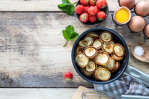 Céréales minuscules aux crêpes aux fraises dans un moule sur fond de bois