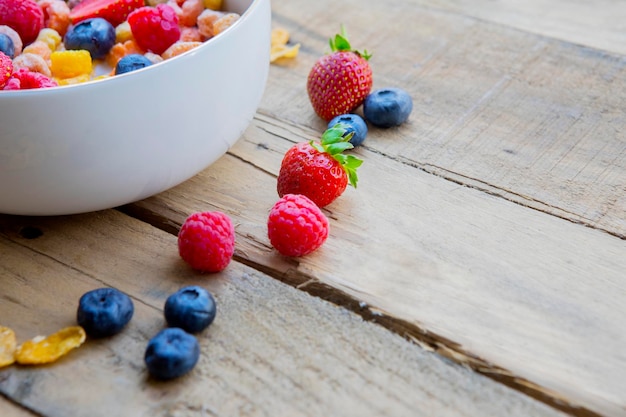 Céréales sucrées avec des baies fraîches sur table en bois