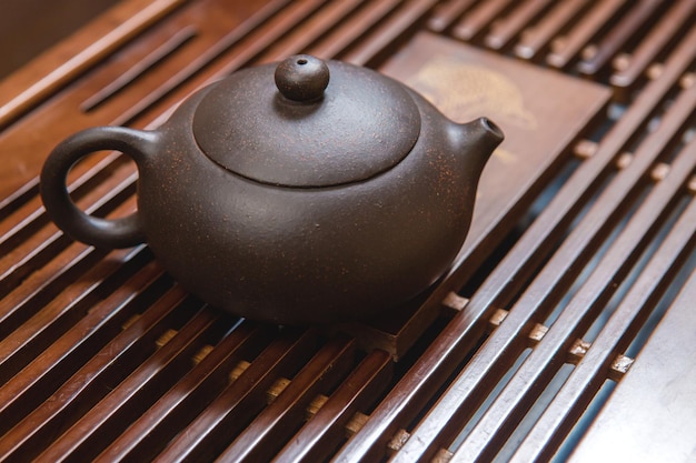 Cérémonie chinoise du thé Théière en céramique faite d'argile et de bols sur un fond en bois