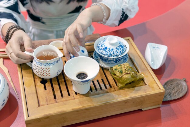 Cérémonie du thé chinoise. La fille verse le thé de la bouilloire dans la tasse.