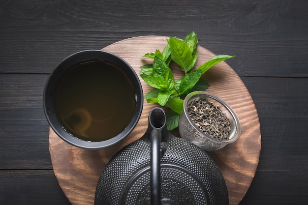 Cérémonie du thé. Tasses de thé avec mélisse et bouilloire sur fond sombre. Concept de thé chinois. Vue d'en-haut.