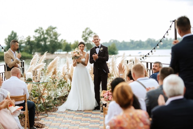 Cérémonie de mariage sur une haute jetée près de la rivière