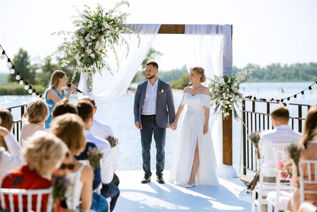 Cérémonie de mariage sur une haute jetée près de la rivière