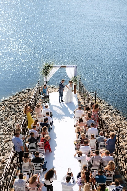 Cérémonie de mariage sur une haute jetée près de la rivière