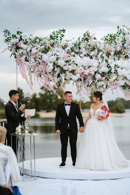 Photo cérémonie de mariage des jeunes mariés sur le quai