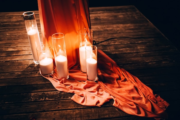 Cérémonie de mariage de nuit. le mariage est décoré d'une arche le soir. guirlande d'ampoules. bougies dans des flacons en verre.