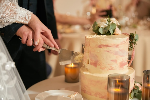 Cérémonie de la première coupe du gâteau de mariage en gros plan sur le côté