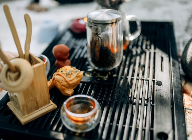 Cérémonie traditionnelle du thé dans le parc Verser du thé rouge dans des tasses en verre