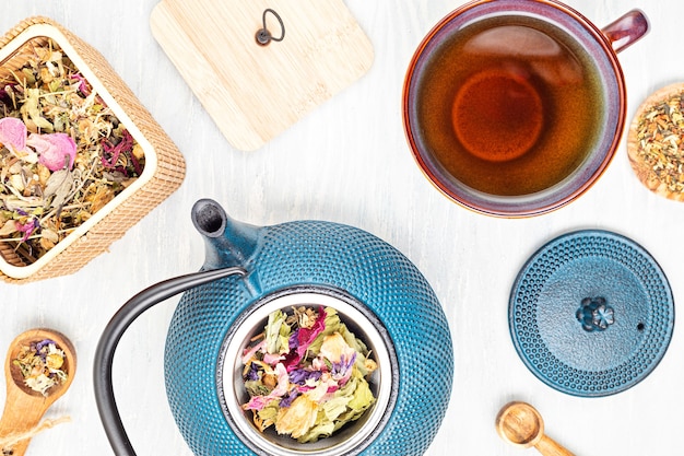 Cérémonie traditionnelle du thé, théière et tasse à thé avec herbes et thé aux fruits secs. Tisane détox, relaxation, guérison, réconfortant sain, concept de thé. Vue de dessus, pose à plat