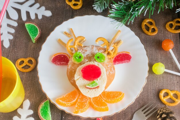 Cerf comestible de Noël de brioches et de marmelade sur une assiette sur une table en bois Nourriture pour enfants de Noël