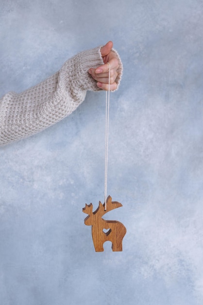 Photo cerf jouet en bois dans des mains féminines ornement de noël durable