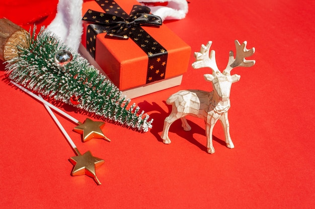 Cerf de jouet de Noël, cadeaux, décorations d'arbre et de Noël sur fond rouge