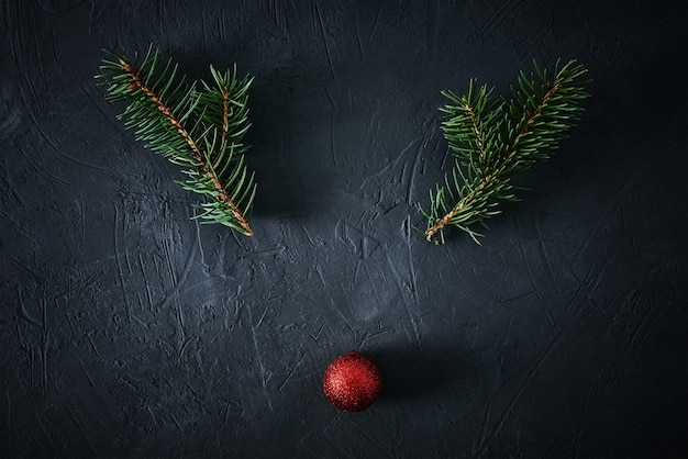 Cerf de Noël en branches de sapin et boule de fête