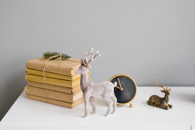 Cerf de Noël dans un décor sur une étagère avec des livres et une horloge