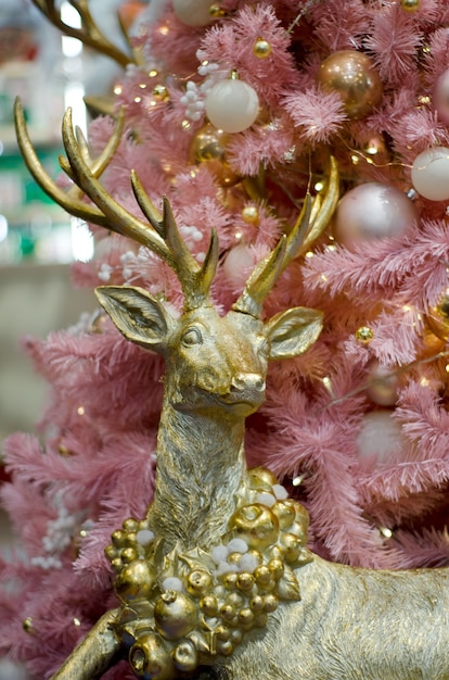 Cerf d'or sur le sapin de Noël rose.