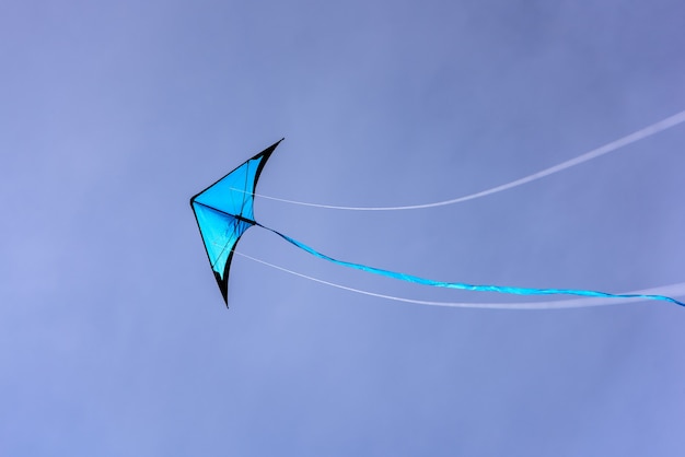 Photo cerf-volant bleu flottant dans le ciel bleu kite avec fond de ciel bleu