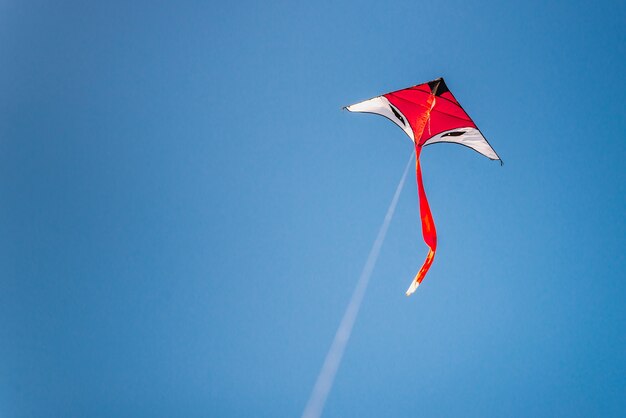 Cerf-volant coloré volant dans le ciel bleu