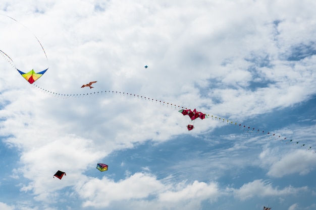 Photo cerfs-volants volant dans le ciel parmi les nuages. festival de cerf-volant