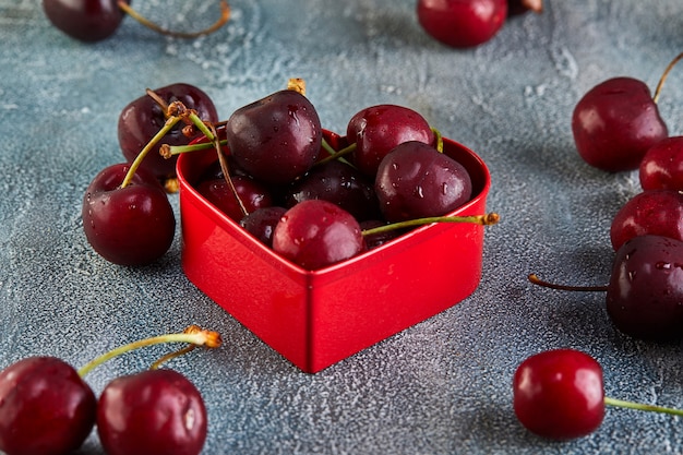 Cerise fraîche ou cerise avec des gouttes d&#39;eau avec un coeur rouge. Concept pour la Saint Valentin