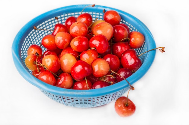 Cerise fraîche avec goutte d'eau dans une passoire bleue