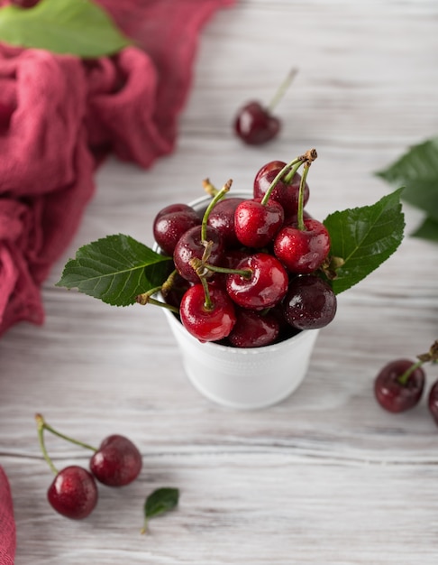 Cerise fraîche avec des gouttes d'eau sur une table en bois rustique.