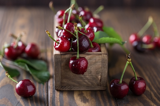 Cerise fraîche avec des gouttes d'eau sur une table en bois rustique.