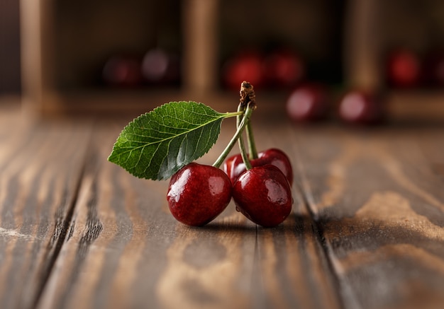 Cerise fraîche avec des gouttes d'eau sur une table en bois rustique.