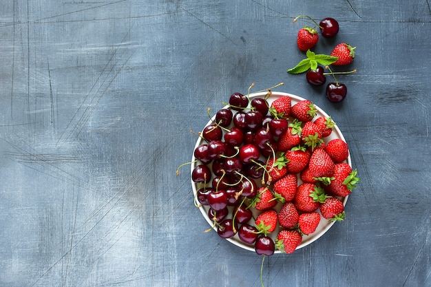 cerise et fraise sur une assiette blanche. aliments sains, vitamines. déjeuner d&#39;été