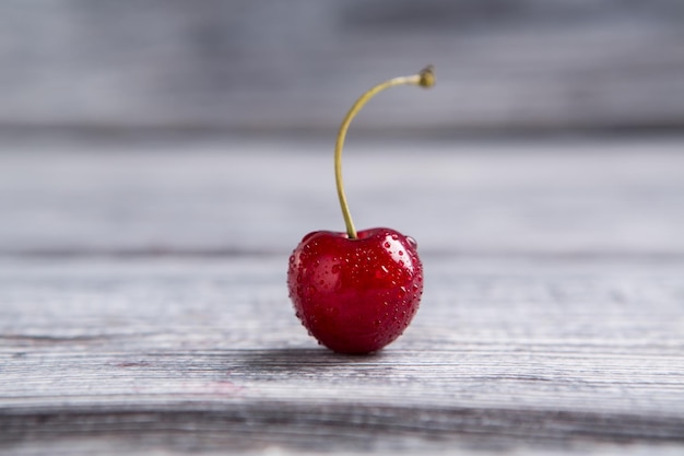 Cerise humide sur une surface grise fruit rouge propre grande quantité de mélatonine petites gouttes d'eau