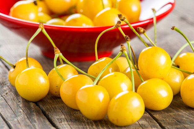 Cerise jaune dans un bol sur un fond en bois