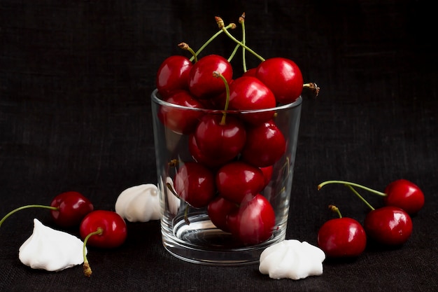 Cerise mûre dans un verre sur fond noir