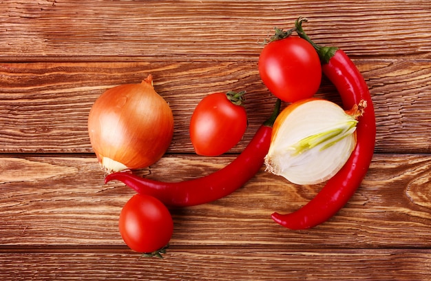 Cerise et piments rouges sur fond de bois blanc oignon