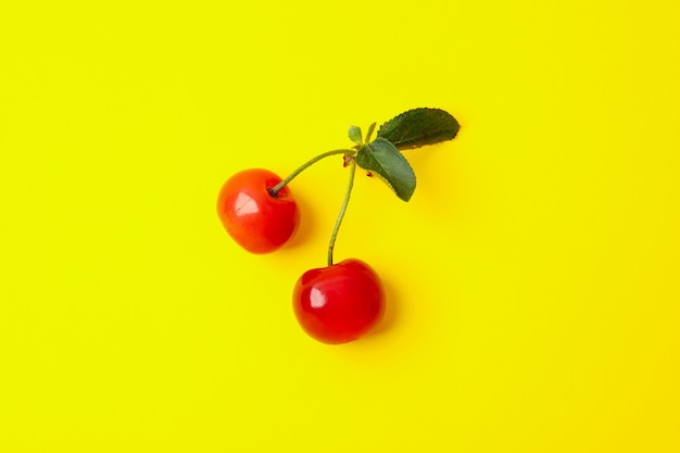 Cerise rouge fraîche sur l'espace jaune, gros plan